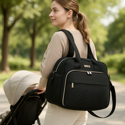 une poussant une poussette avec le sac a langer sur le dos